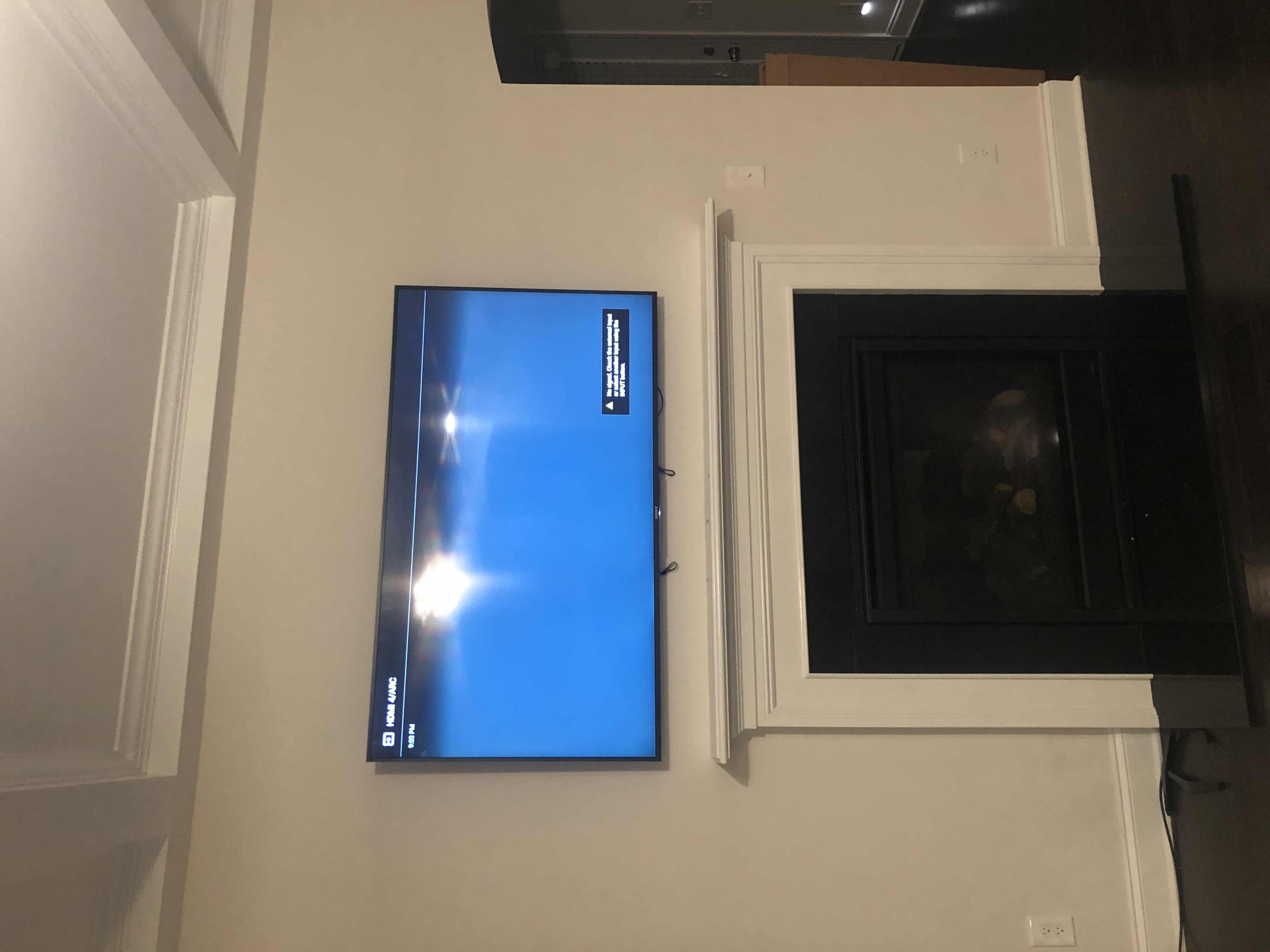 Full-motion TV mounting on drywall wall in living room, service area