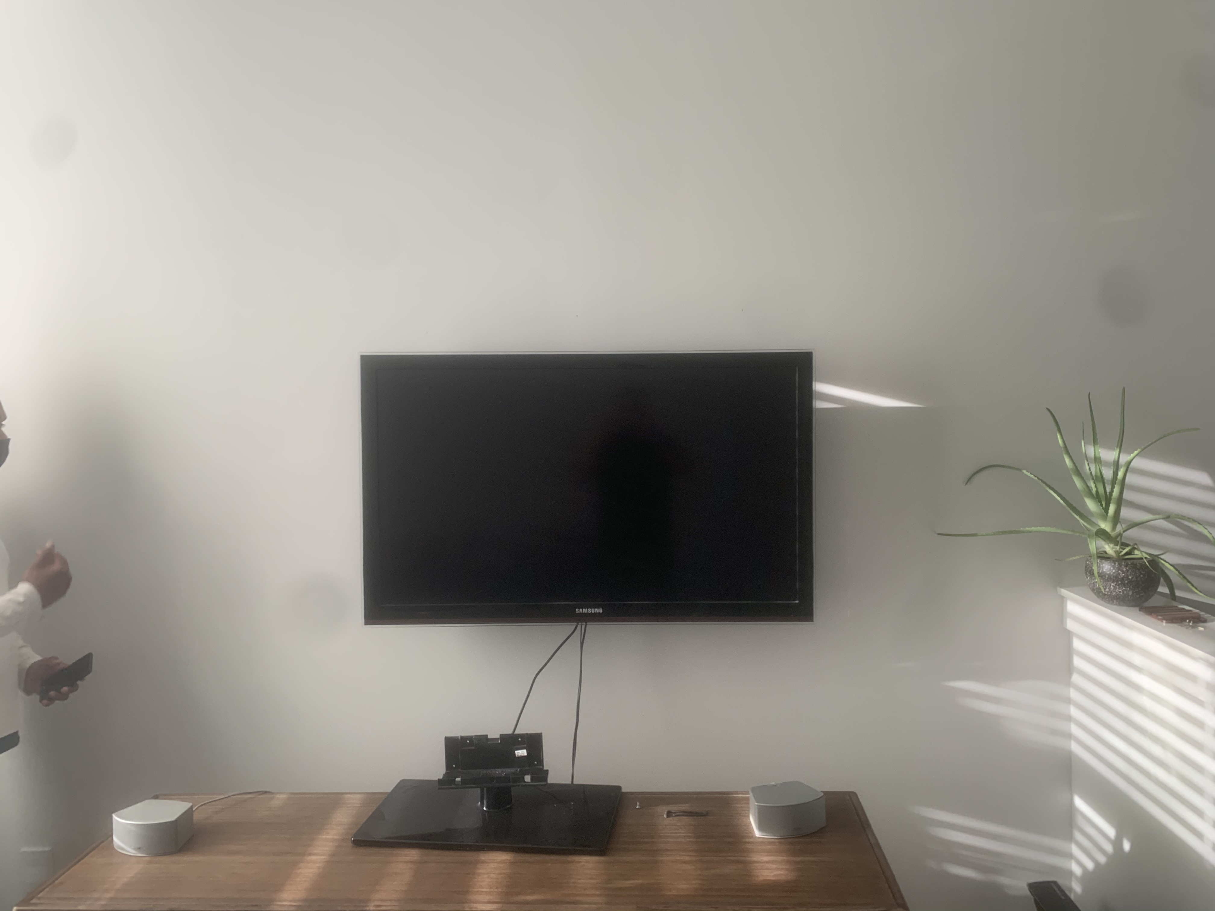 Full-motion TV mounting on drywall wall in living room, service area