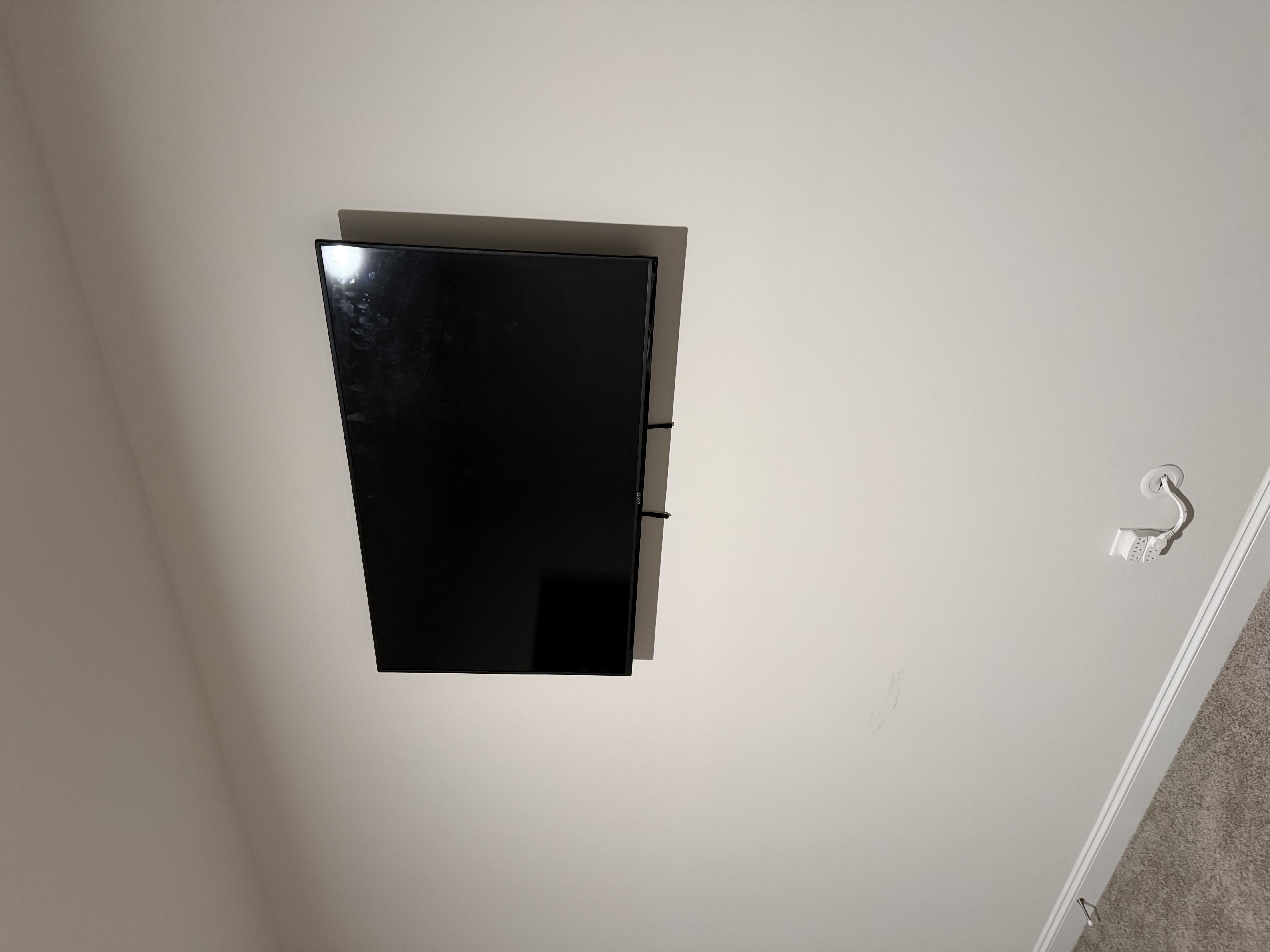 Tilting TV mounting on drywall wall in living room, service area