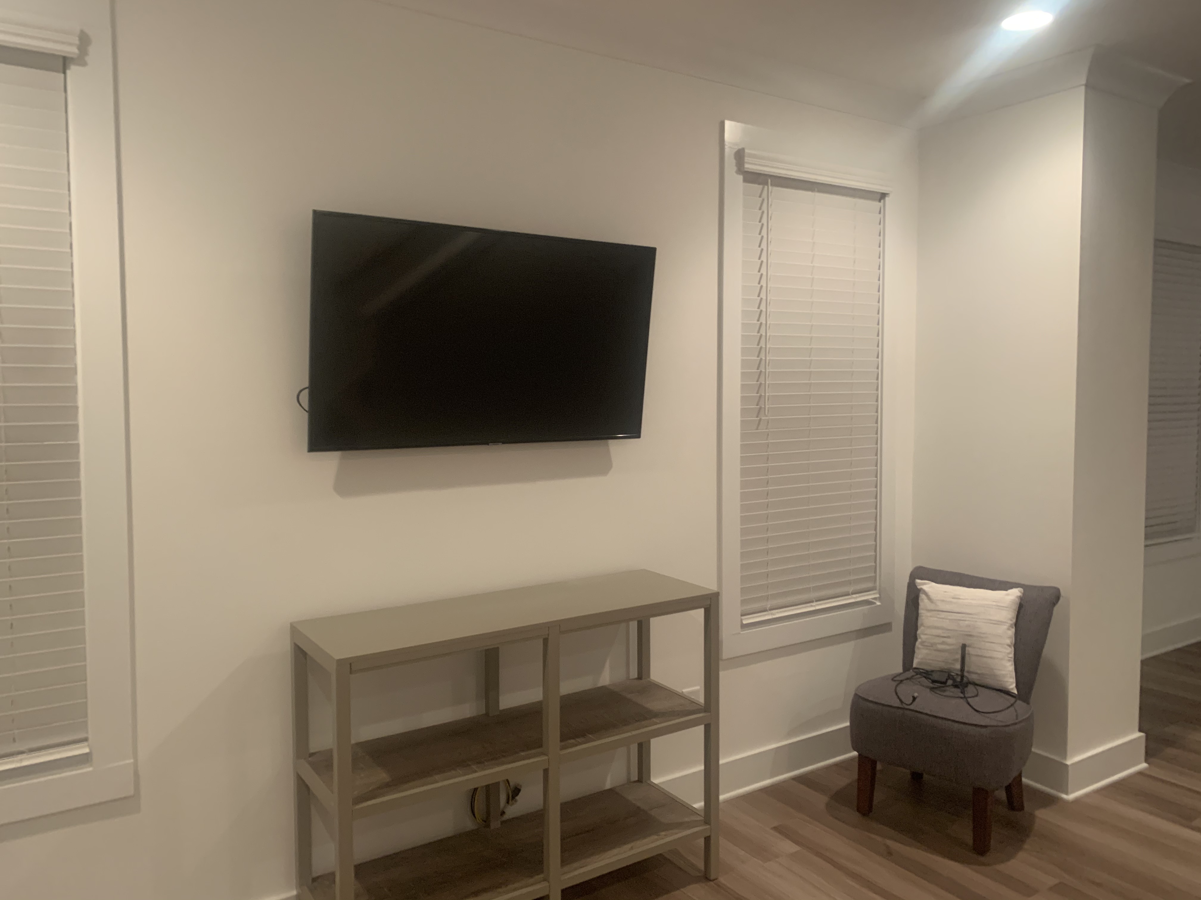 Tilting TV mounting on drywall wall in living room, service area