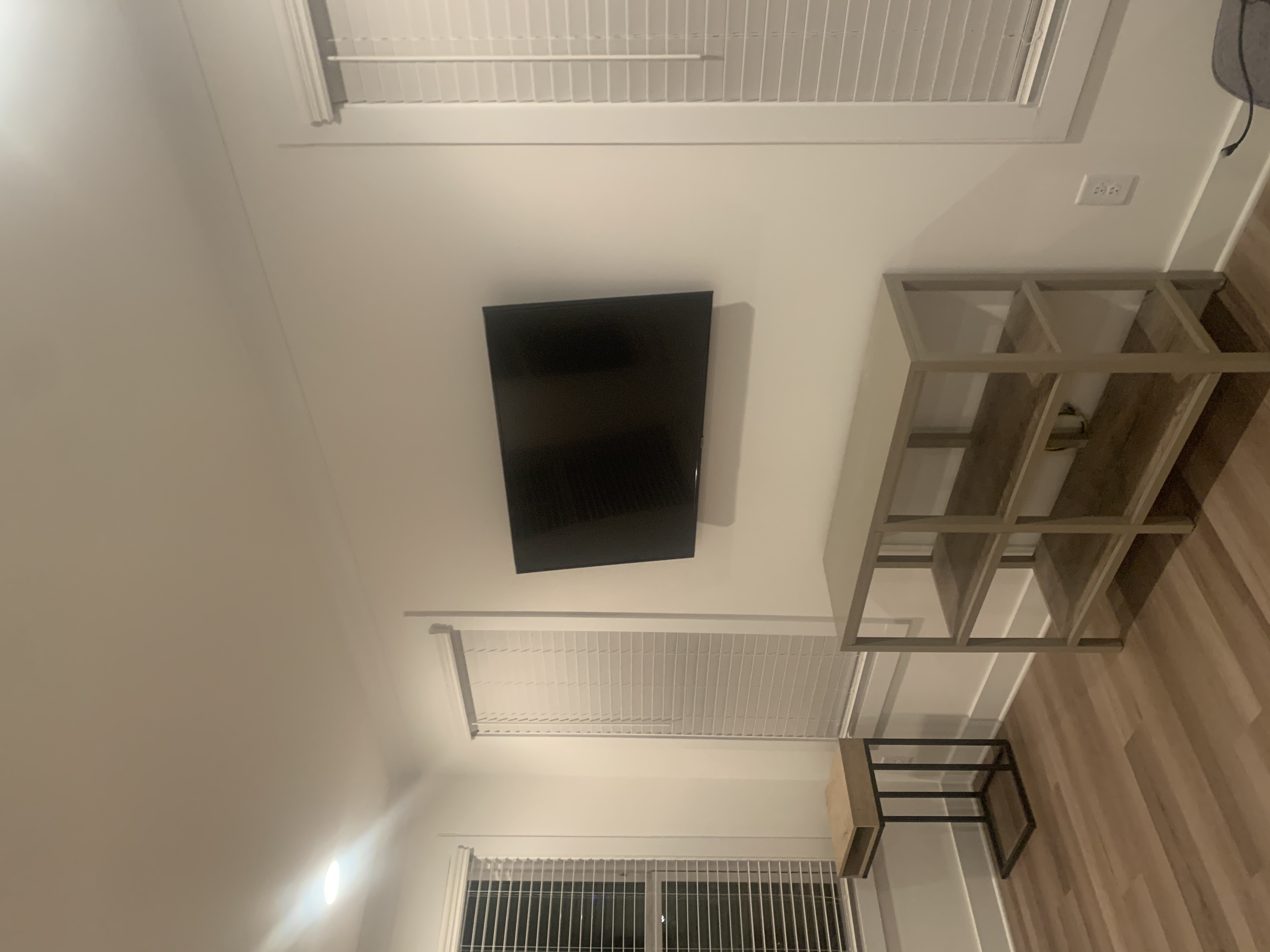 Full-motion TV mounting on drywall wall in living room, service area