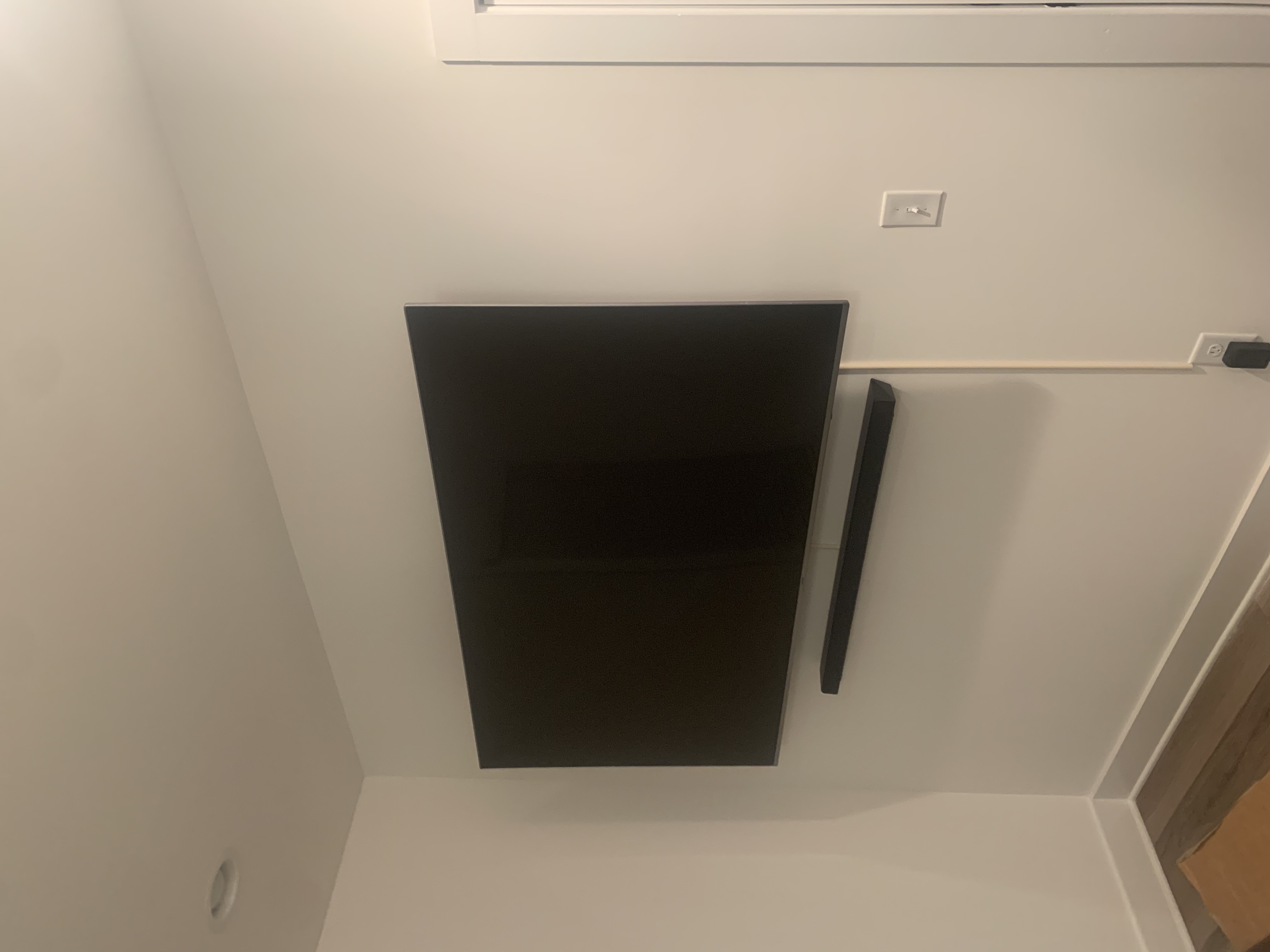 Tilting TV mounting on drywall wall in living room, service area