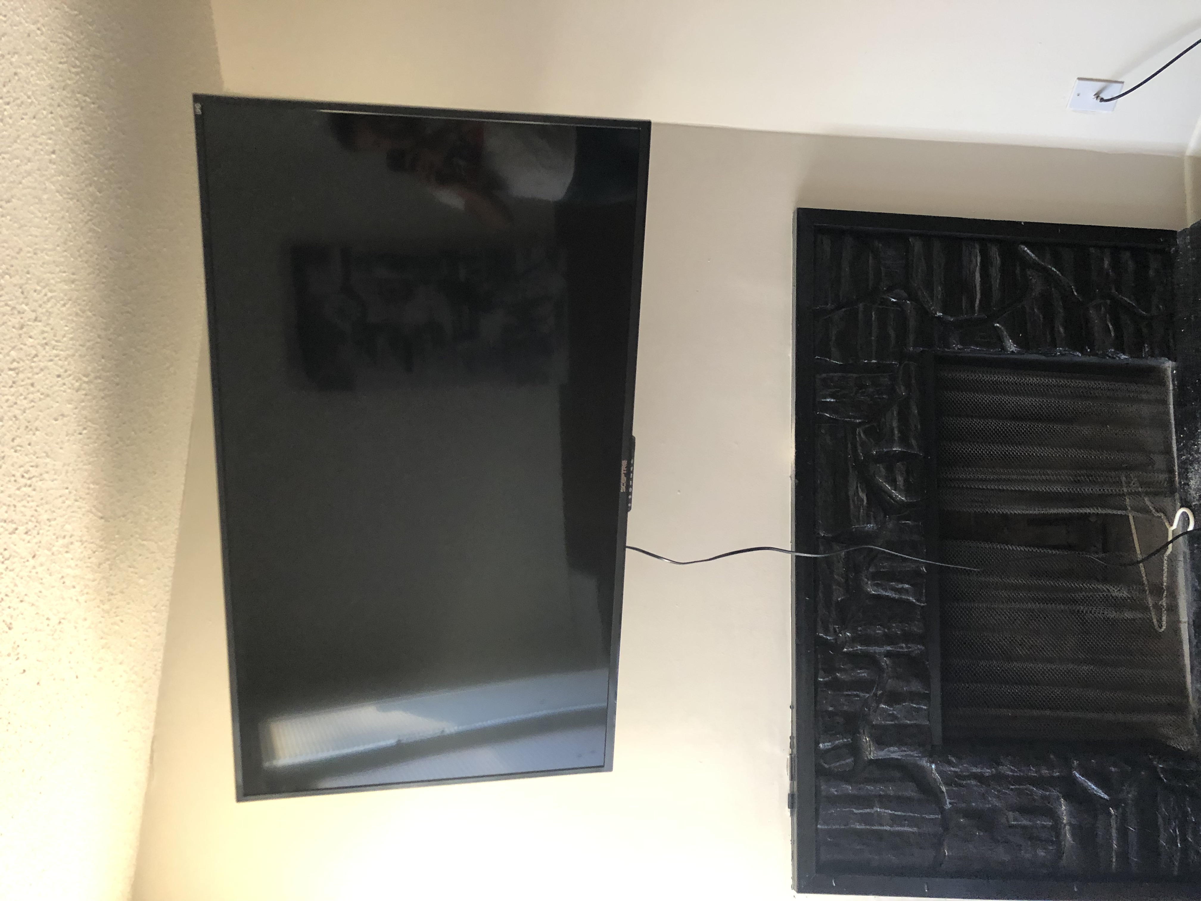 Tilting TV mounting on drywall wall in living room, service area