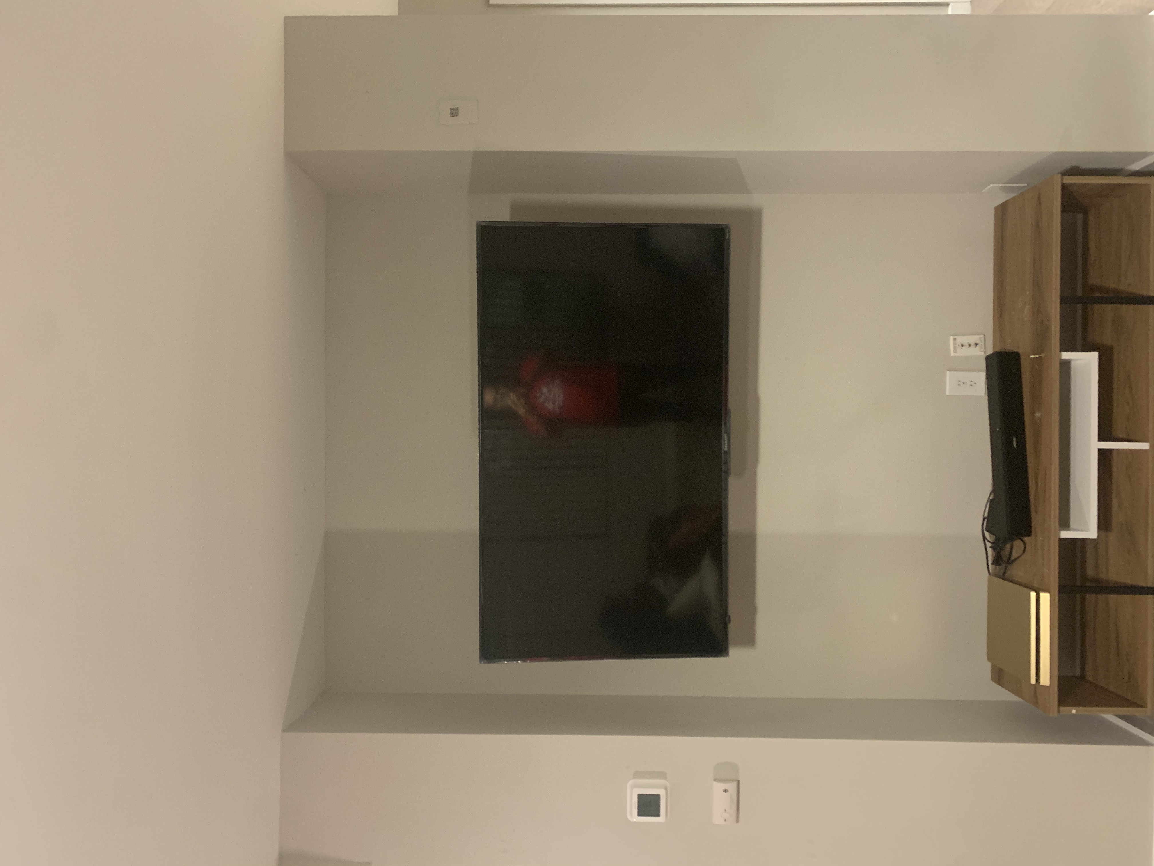 Tilting TV mounting on drywall wall in living room, service area