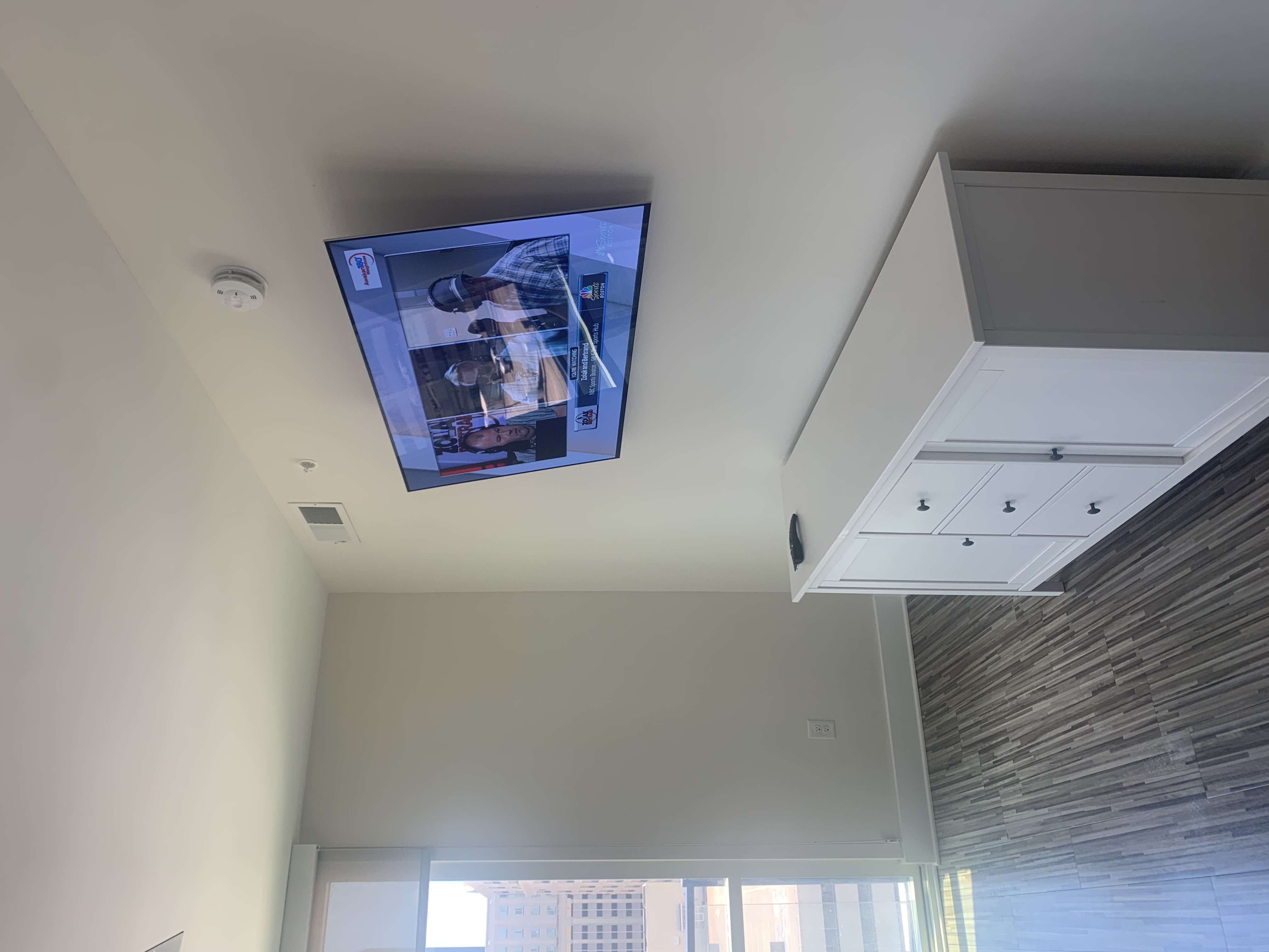 Full-motion TV mounting on drywall wall in living room, service area