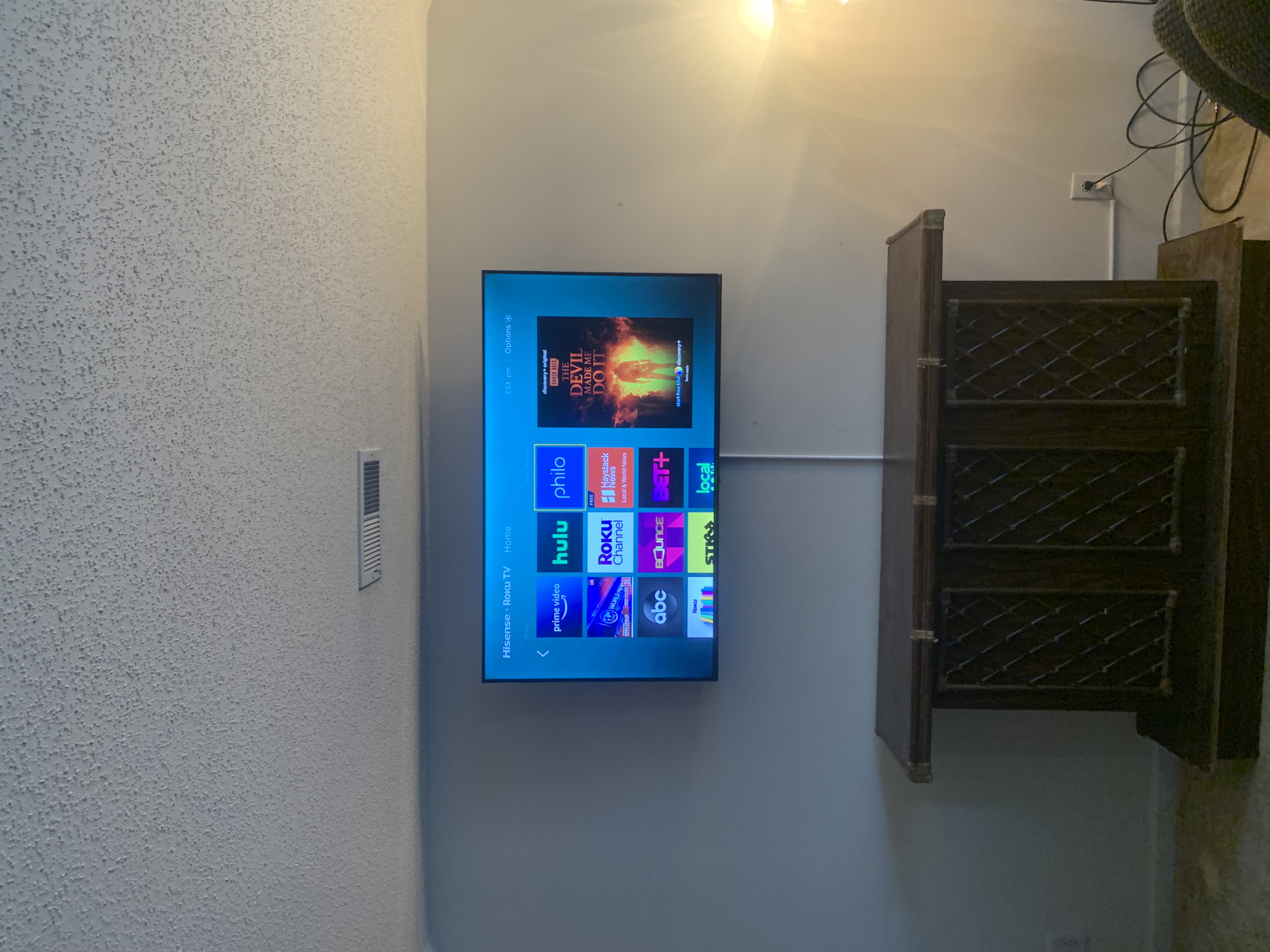 Full-motion TV mounting on drywall wall in living room, service area