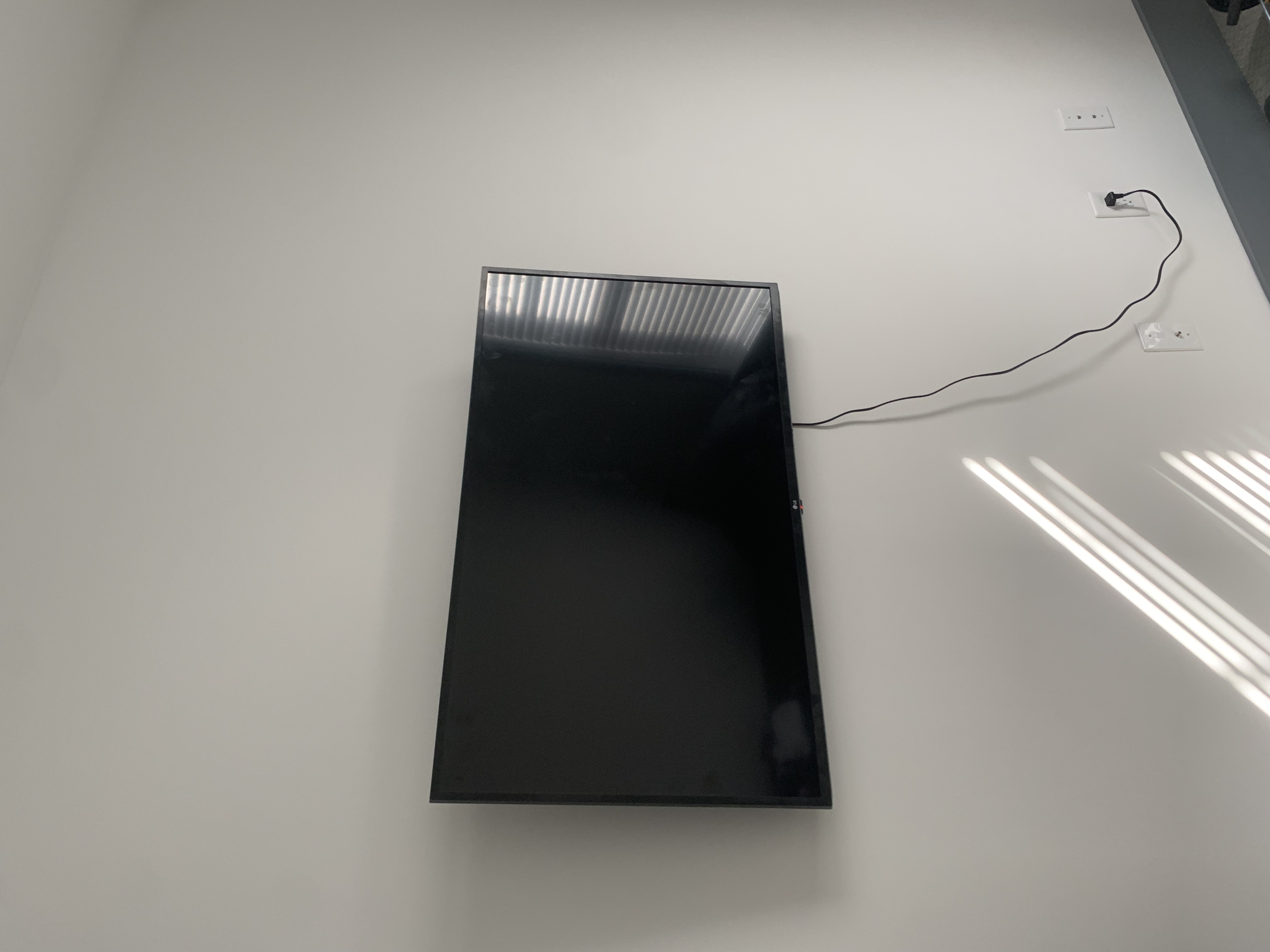 Tilting TV mounting on drywall wall in living room, service area