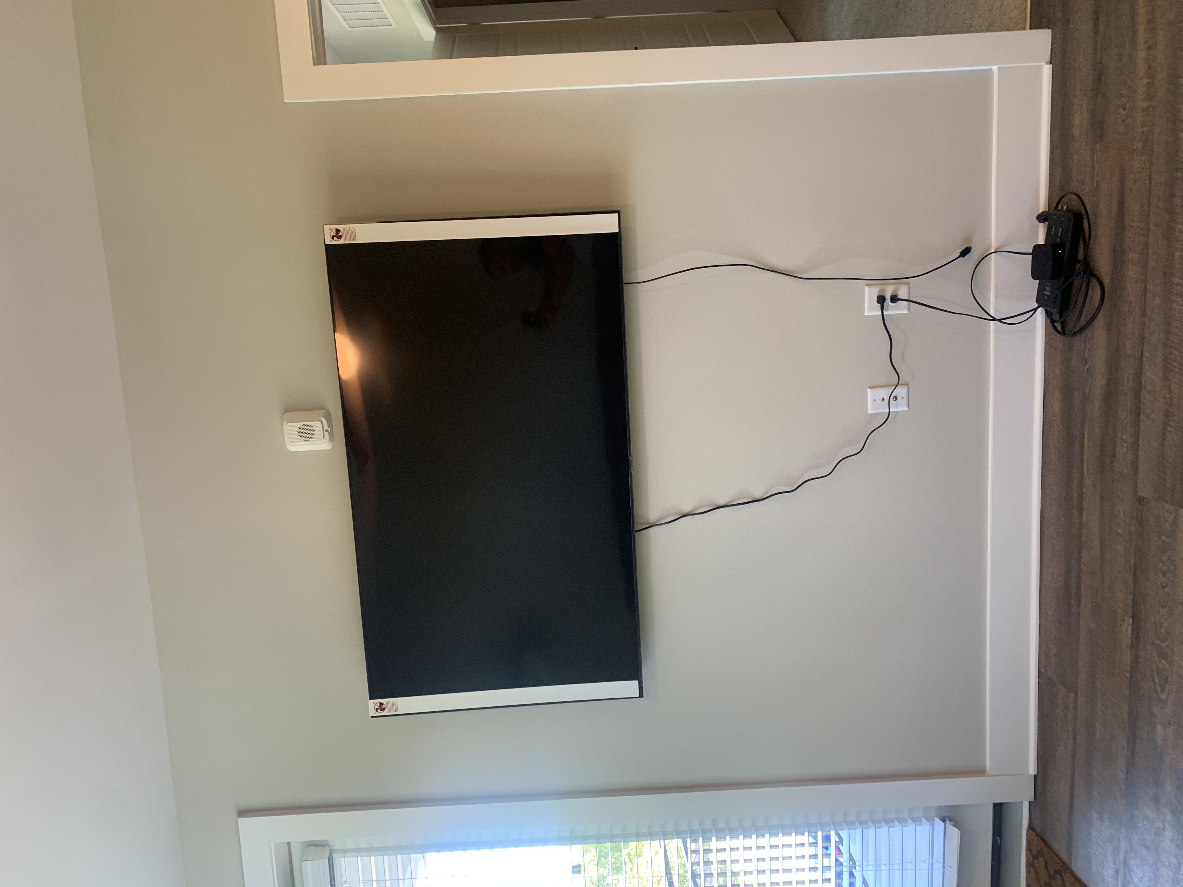Full-motion TV mounting on drywall wall in living room, service area
