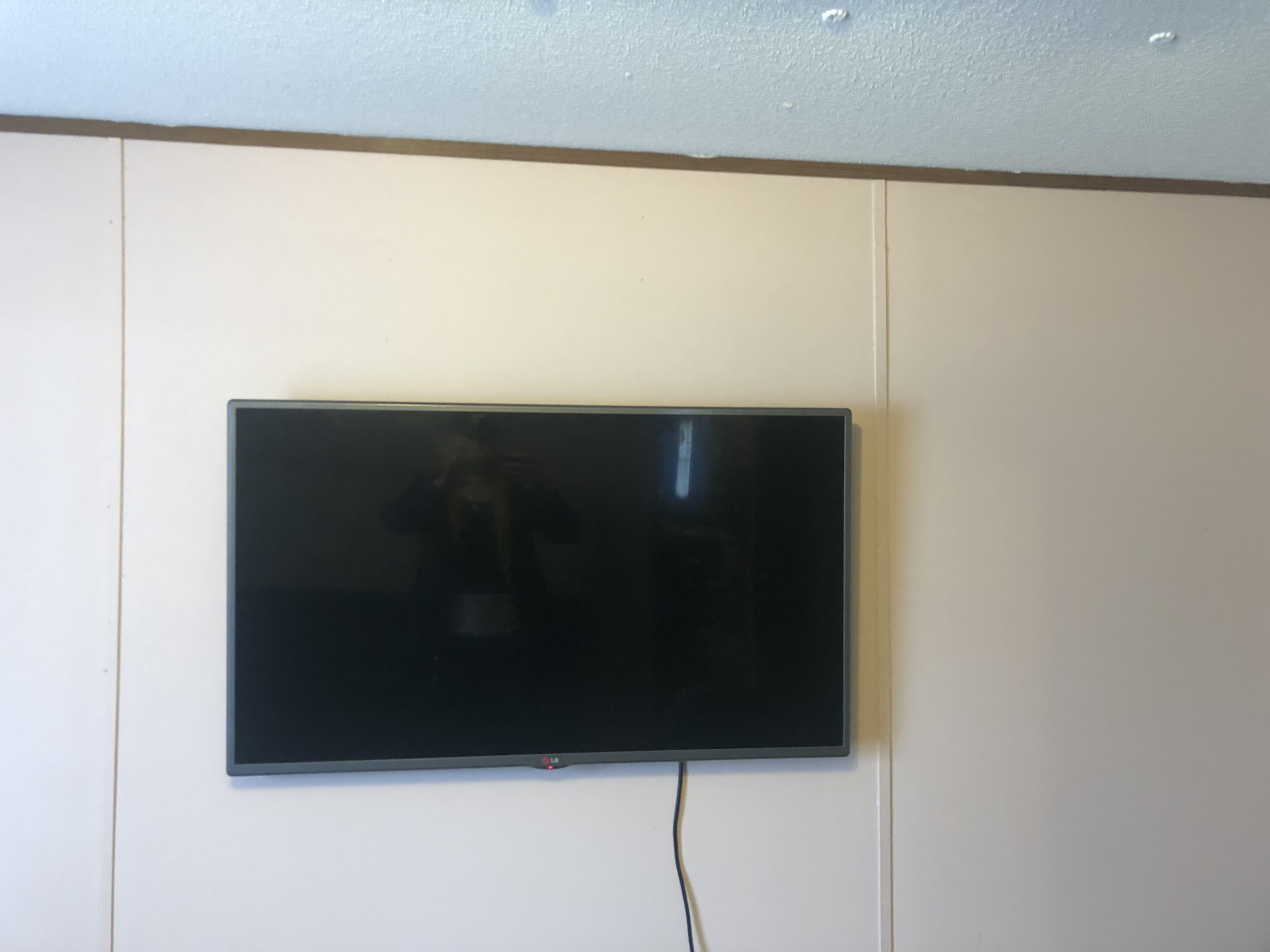 Tilting TV mounting on drywall wall in living room, service area
