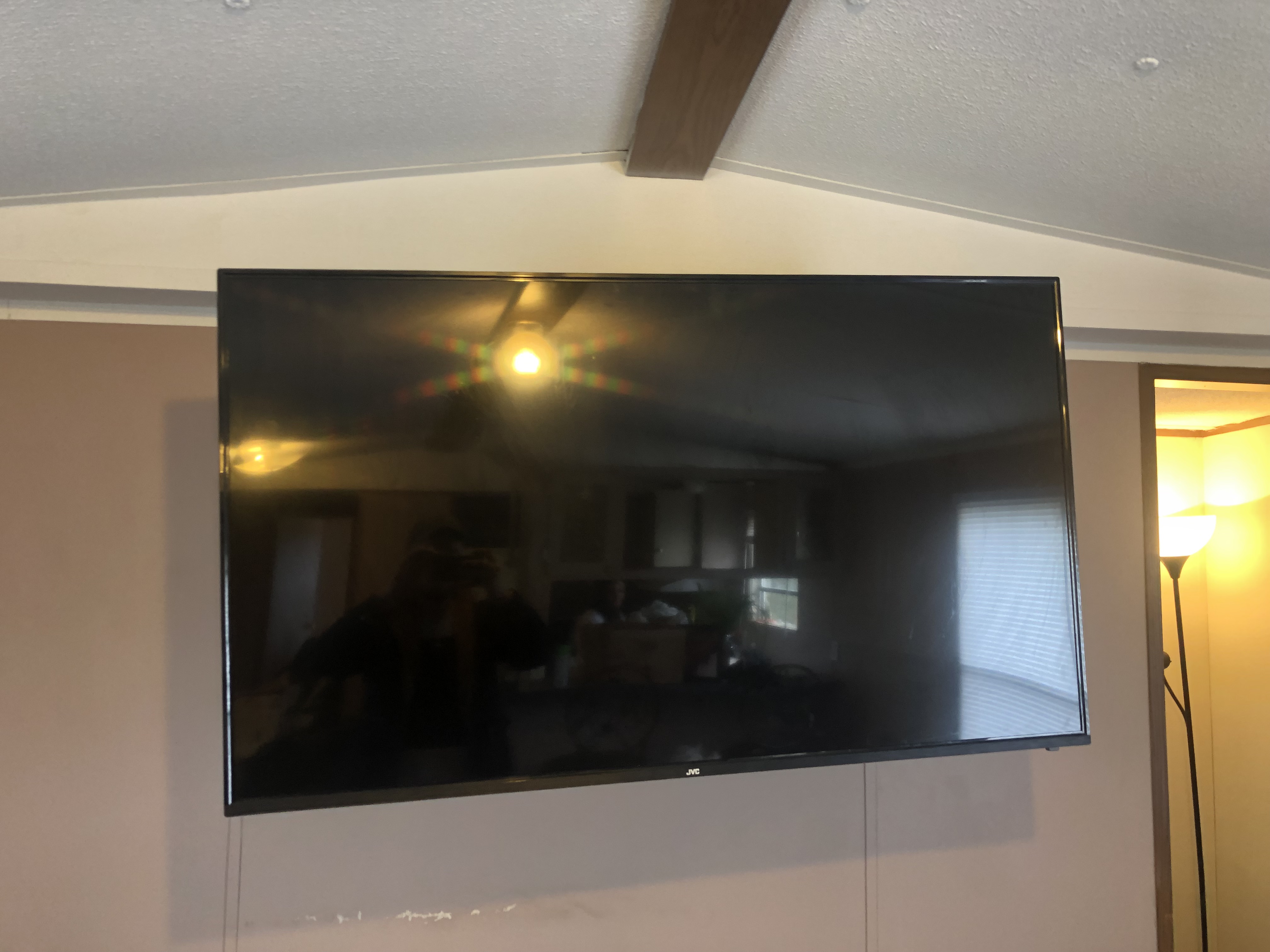 Fixed TV mounting on drywall wall in living room, service area
