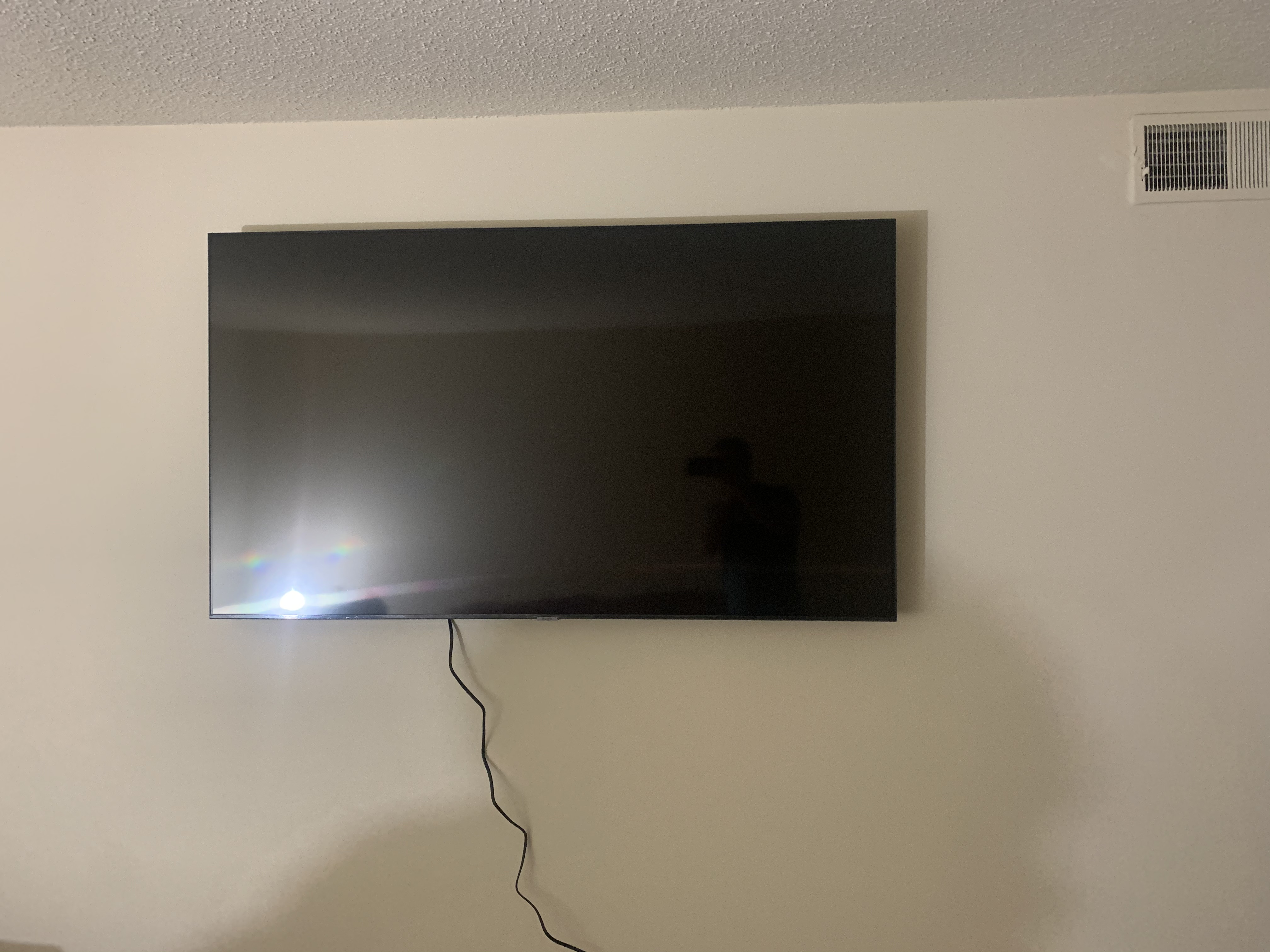Fixed TV mounting on drywall wall in living room, service area