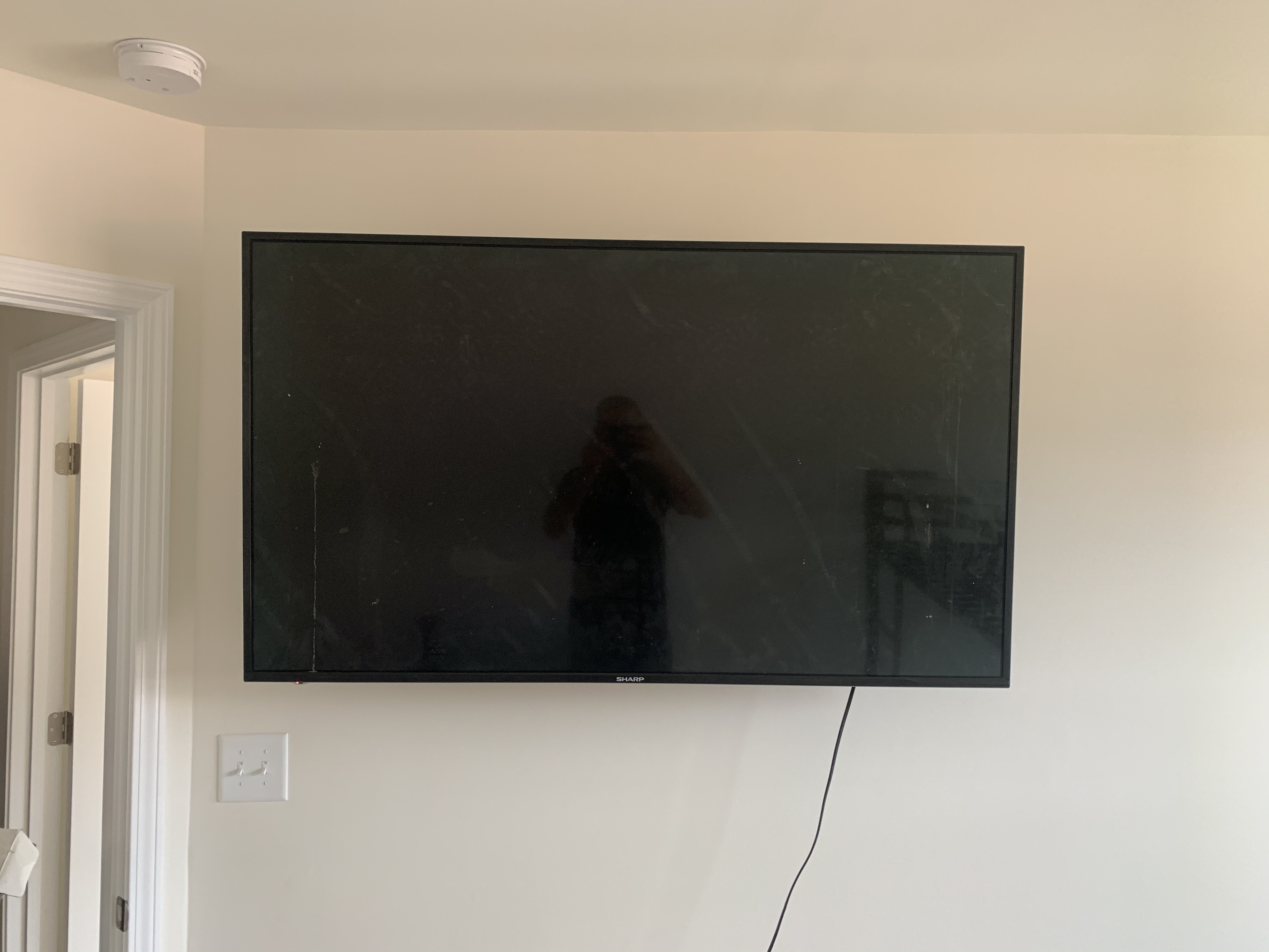 Full-motion TV mounting on drywall wall in living room, service area