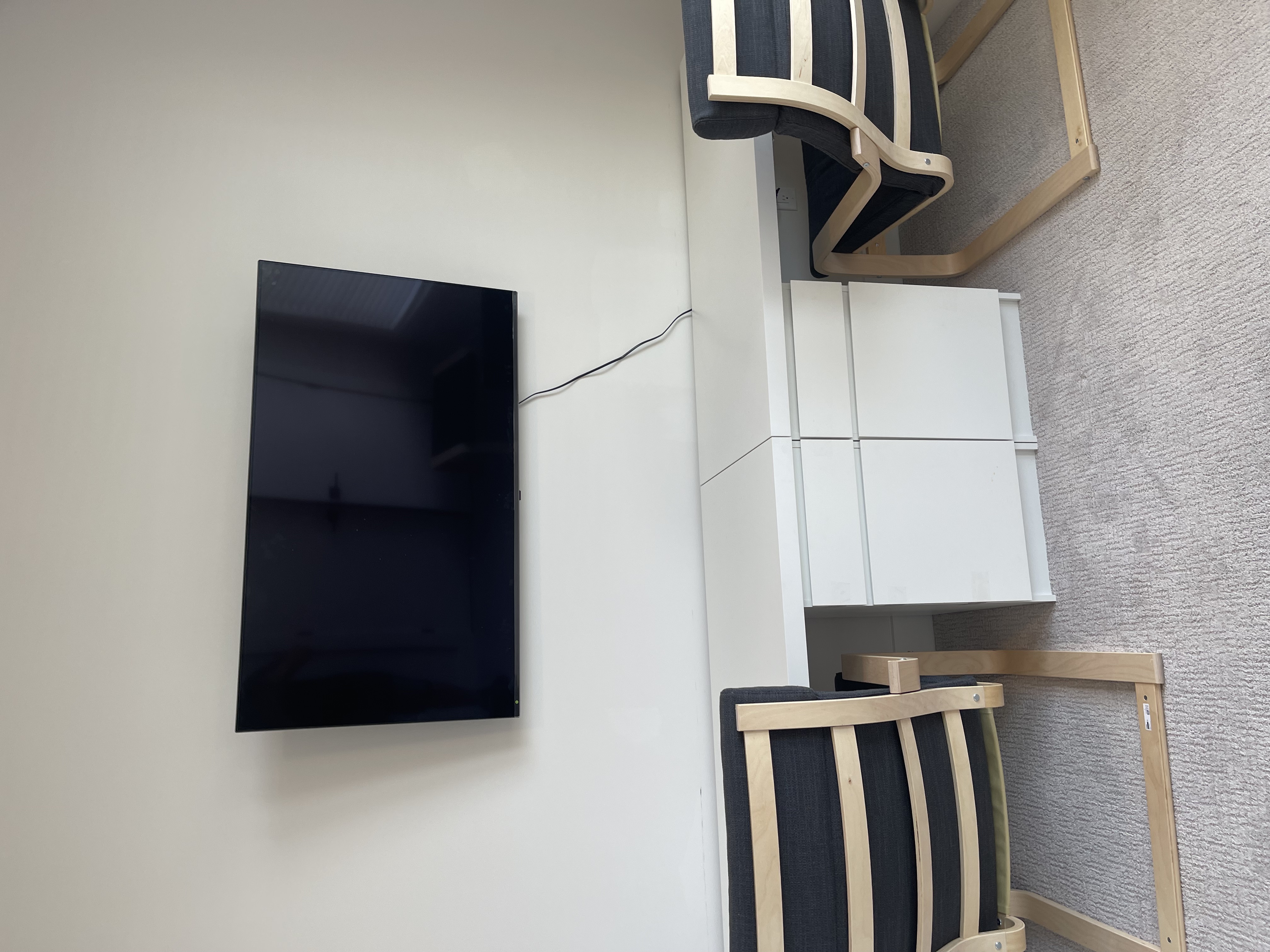 Full-motion TV mounting on drywall wall in living room, service area