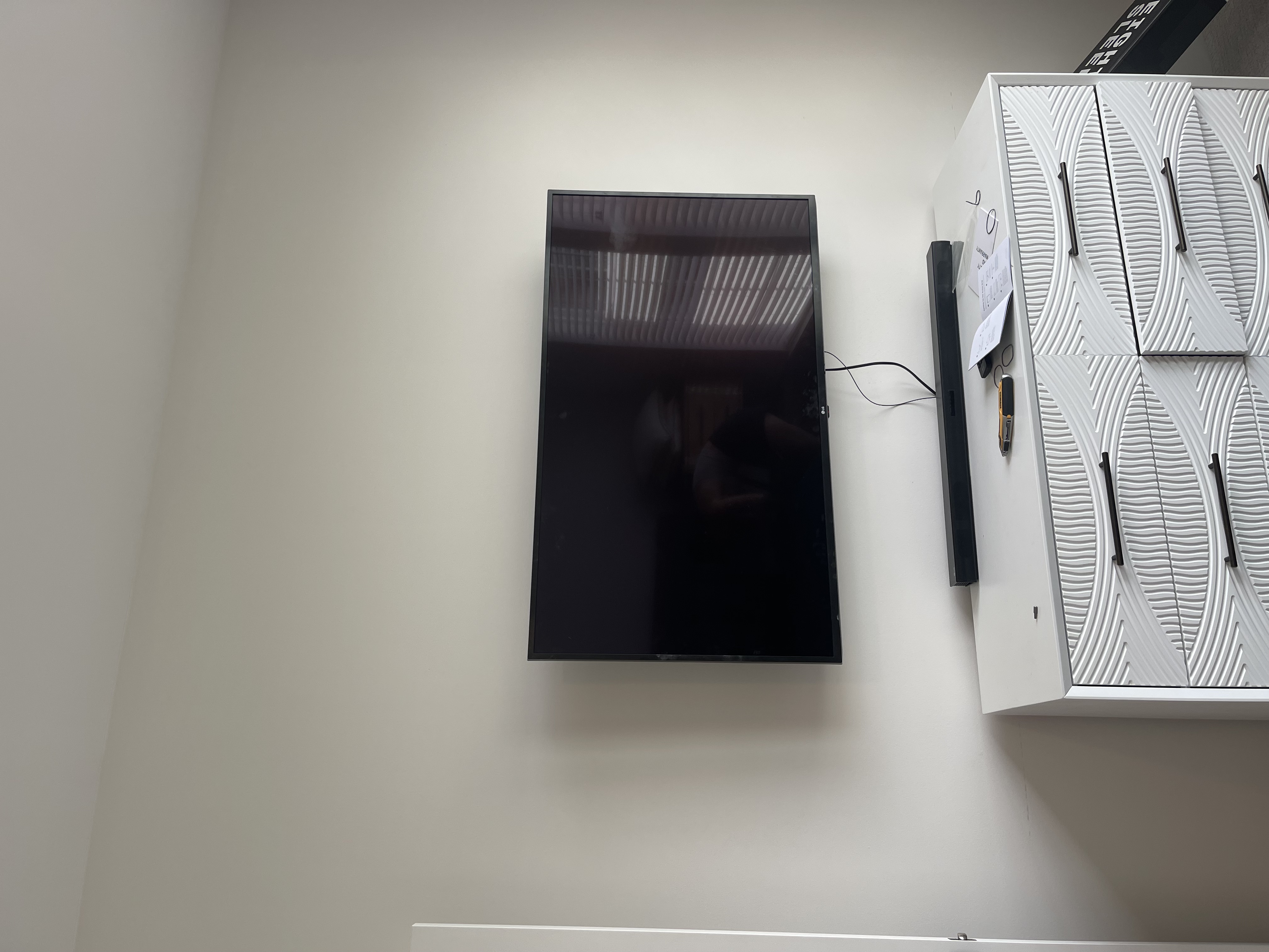 Fixed TV mounting on drywall wall in living room, service area