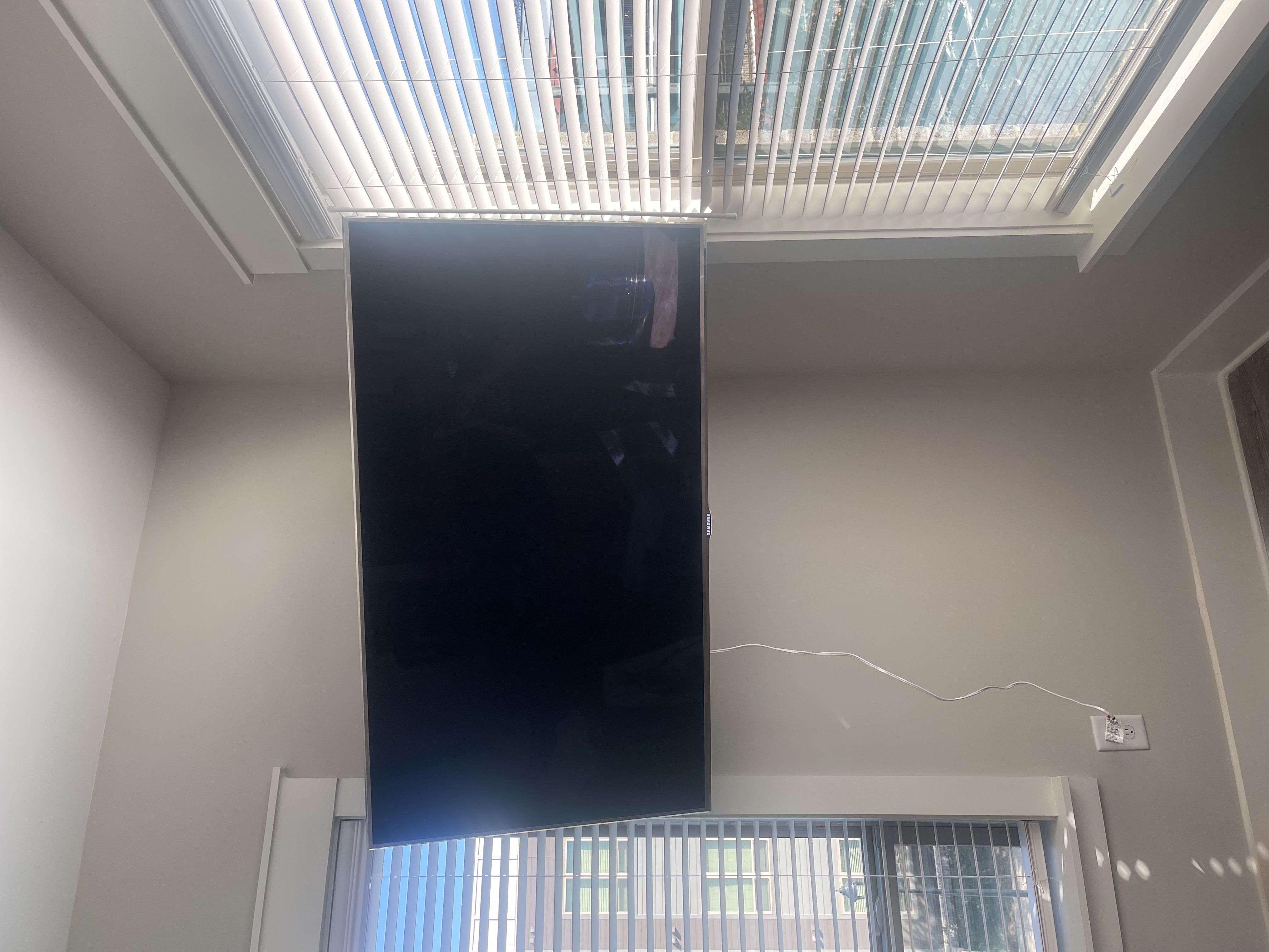 Tilting TV mounting on drywall wall in living room, service area