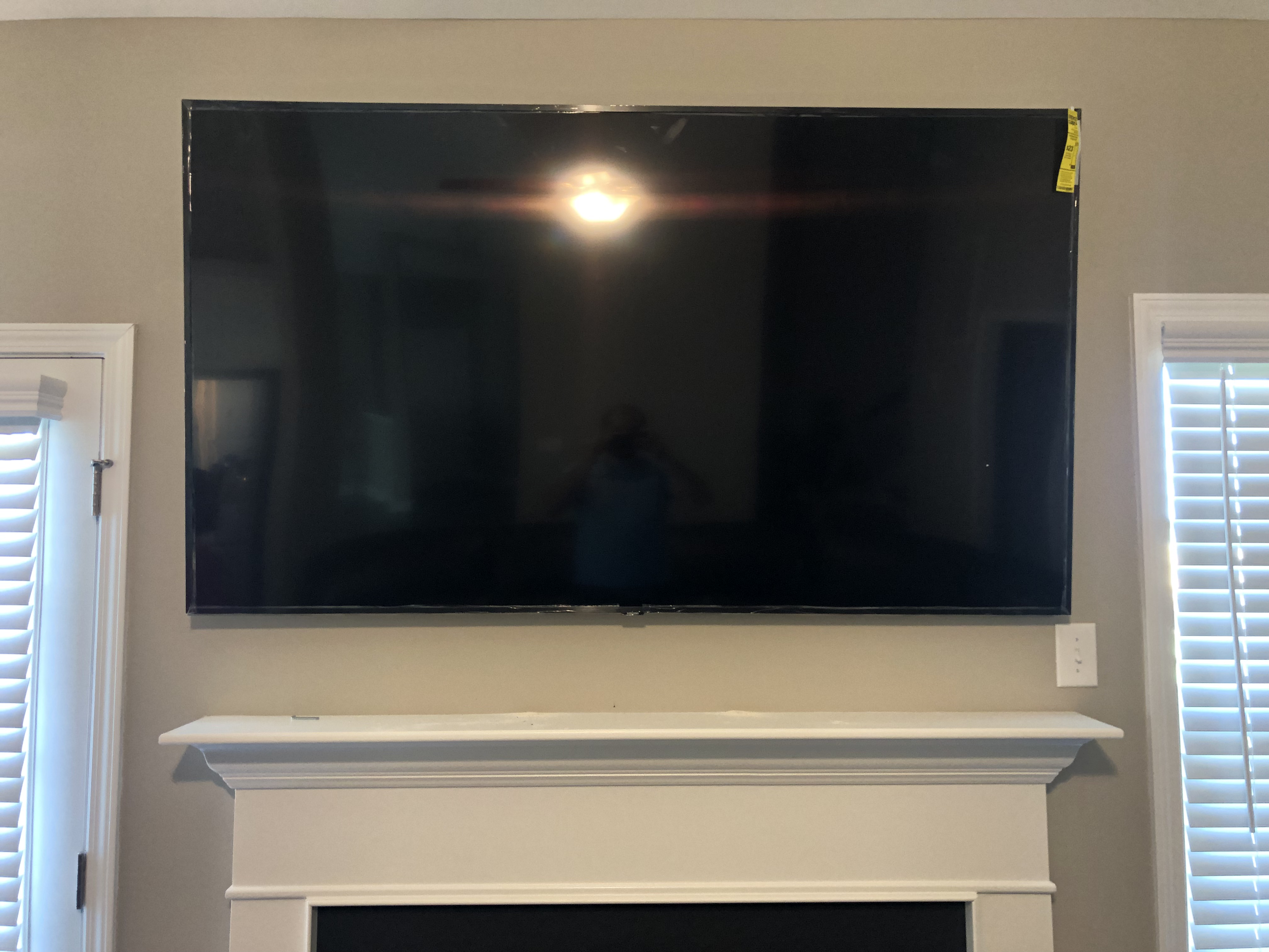 Full-motion TV mounting on drywall wall in living room, service area
